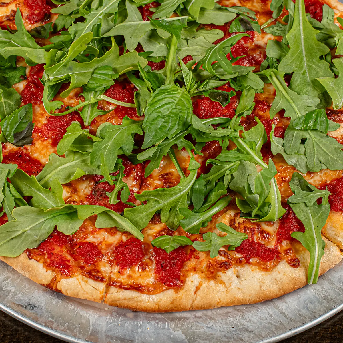Pizza topped with fresh arugula at Wayne Ale House